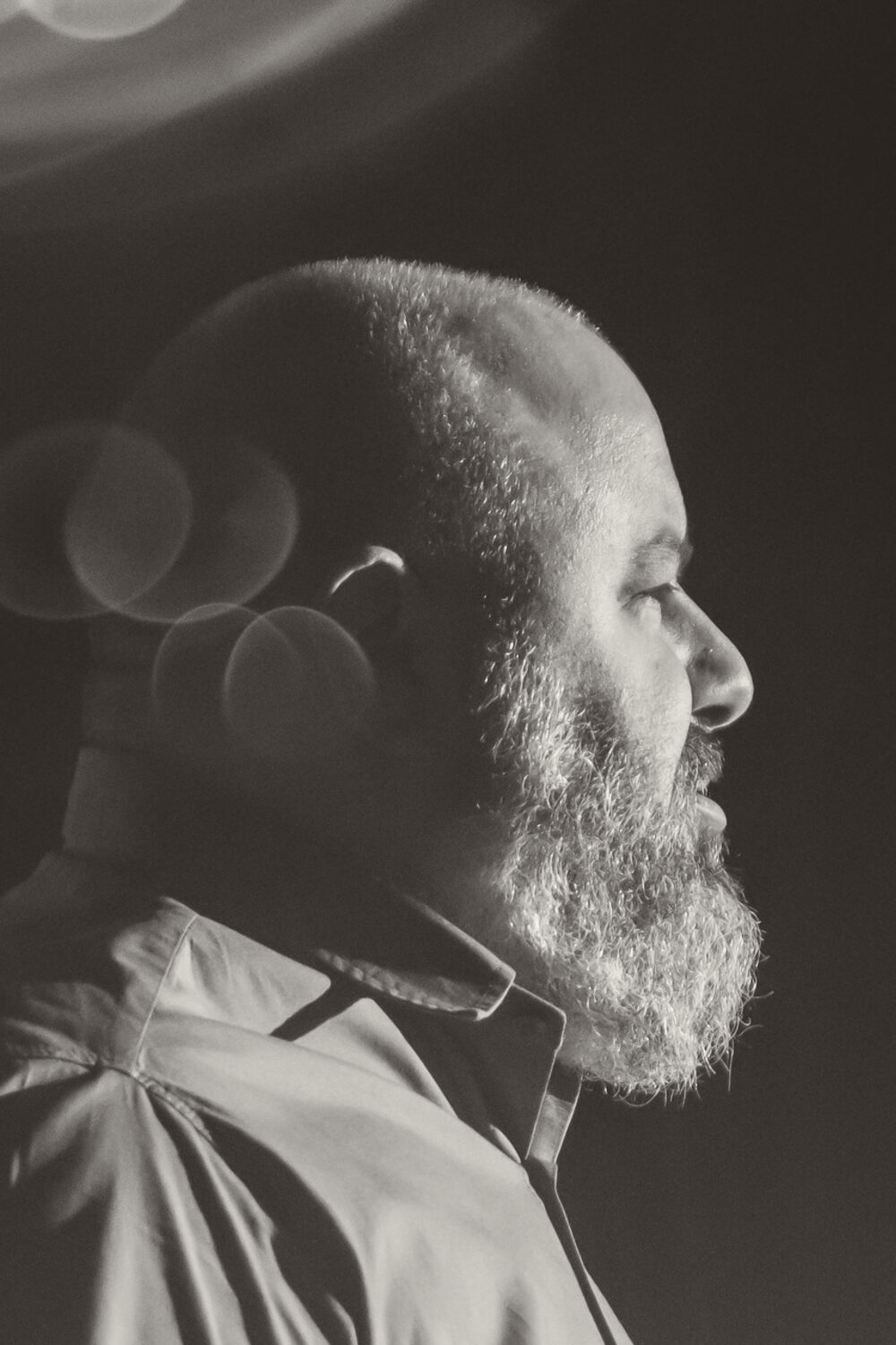 Homem de barba grisalha, de perfil, ouvindo a pregação